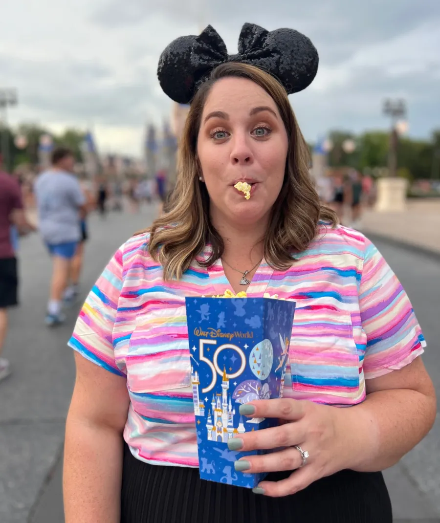 samantha with mickey ears on standing eating Disney popcorn