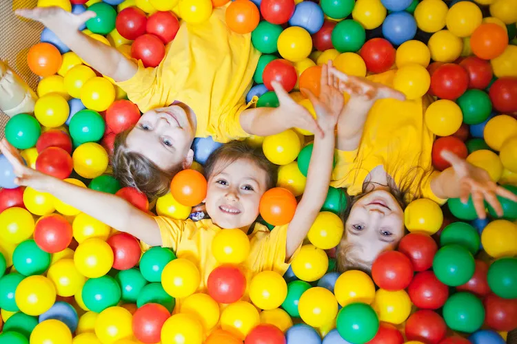 kids laying down playing in a ball pit