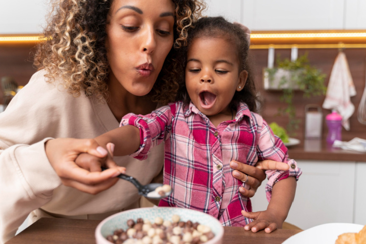 woman feeding her child in the kitchen