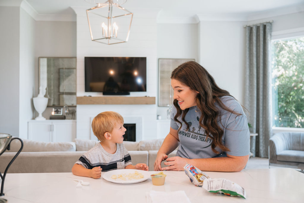 young boy sitting at the table unhappy about eating