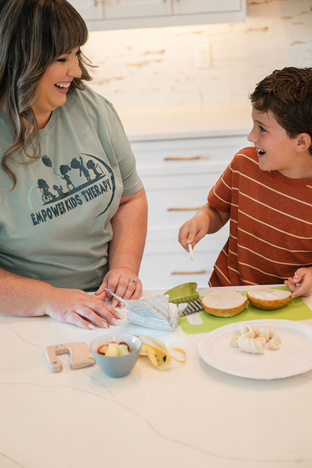Therapist's hand on toy showing child how to manipulate the toy